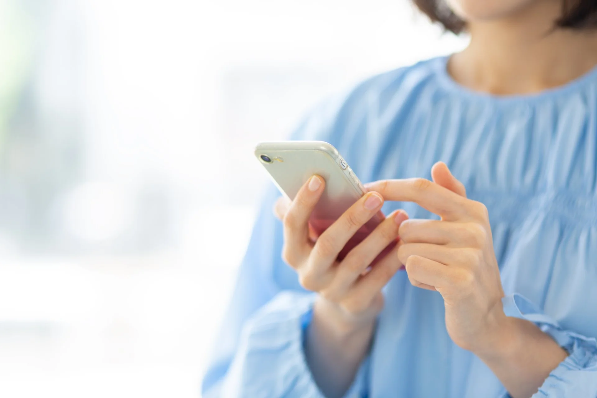 スマートフォンを操作する女性の手元